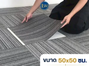 ช่างกำลังวางพรมแผ่นสีเทาลายเส้น ขนาด 50x50 ซม. บนพื้นที่จริง